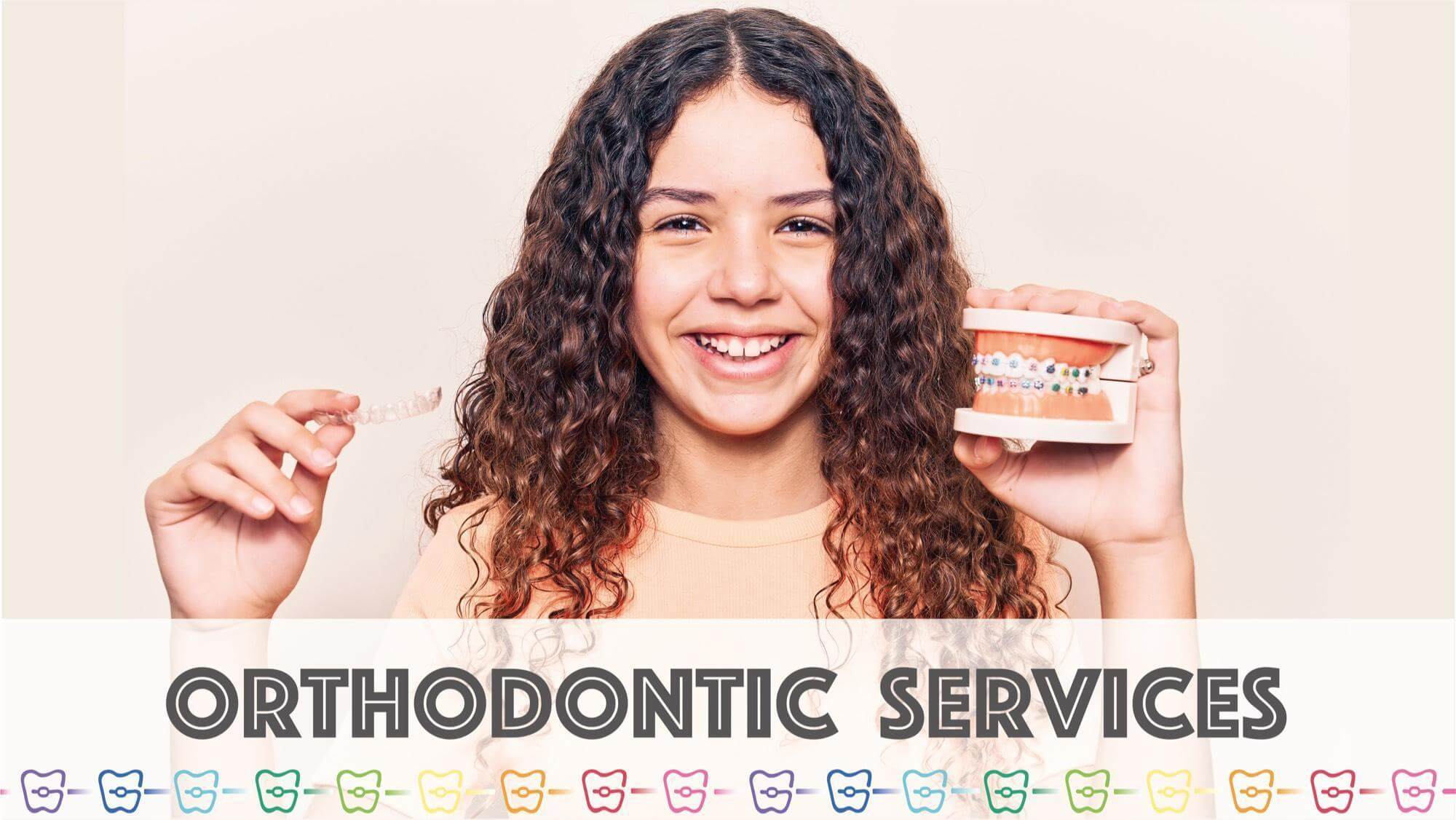 OrthoBoutique - a curley woman smiling holding a fake teeth with braces and a clear aligner