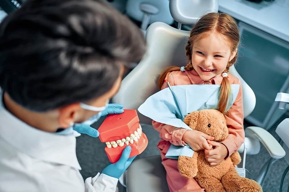 OrthoBoutique - a happy child listening to her dentist